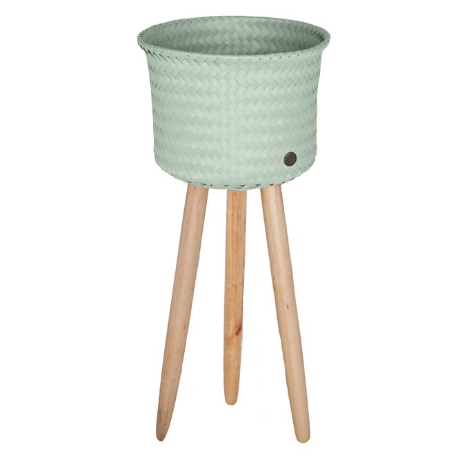 A tall planter with high wooden legs and a pastel green basket. Image by TakaTomo.de.